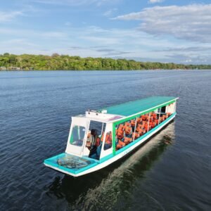 Bote turístico Gando II de Transportes T7 navegando por los canales de Tortuguero con pasajeros y medidas de seguridad.